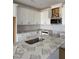 Modern white kitchen with stainless steel appliances, a stylish backsplash, and stone countertops at 52 Shay St, Angier, NC 27501