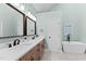 Stylish bathroom featuring a double vanity and soaking tub with unique window feature at 5317 Chimney Swift Dr, Wake Forest, NC 27587