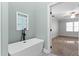 A modern bathroom with a soaking tub and an adjacent bedroom view at 5317 Chimney Swift Dr, Wake Forest, NC 27587
