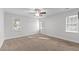 This bright bedroom has neutral walls, carpet, and a ceiling fan with plenty of natural light from two windows at 5317 Chimney Swift Dr, Wake Forest, NC 27587