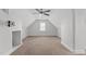 This large, open bonus room is carpeted and features a ceiling fan and a single window at 5317 Chimney Swift Dr, Wake Forest, NC 27587
