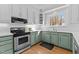 Bright kitchen with white subway tile, marbled countertops, green cabinetry, and stainless steel appliances at 5317 Chimney Swift Dr, Wake Forest, NC 27587