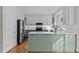 Bright kitchen with white subway tile, marbled countertops, green cabinetry, and stainless steel appliances at 5317 Chimney Swift Dr, Wake Forest, NC 27587