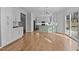 Open-concept kitchen with white cabinets, light green island, stainless steel appliances, and hardwood floors at 5317 Chimney Swift Dr, Wake Forest, NC 27587