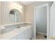 Well-lit bathroom with a large round mirror, white vanity, and a view into the toilet room at 535 Darby Glen Ln, Durham, NC 27713