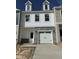 Charming townhouse with white siding, stone accents, and a one-car garage provides a stylish facade at 58 Shay St, Angier, NC 27501