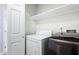 Functional laundry room featuring a washing machine, dryer, and ample shelving for organized storage at 5840 Branchwood Rd, Raleigh, NC 27609
