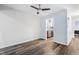 Room with wood floors, a ceiling fan, and an open doorway to the kitchen at 5840 Branchwood Rd, Raleigh, NC 27609