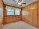 Bedroom with a ceiling fan, window, carpeted flooring and wooden paneling at 6605 Pearces Rd, Louisburg, NC 27549