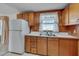 Charming kitchen features wooden cabinetry, a window over the sink, and white appliances at 6605 Pearces Rd, Louisburg, NC 27549