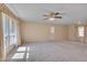 Spacious living area with carpet, a ceiling fan, and large window, perfect for relaxing and entertaining at 6605 Pearces Rd, Louisburg, NC 27549