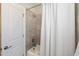 Bathroom with tile-surround tub and shower with a white curtain and a white door at 8013 Ghost Pony Trl, Raleigh, NC 27613