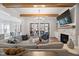 Open living room with wood beam ceiling, stone fireplace, and access to dining area and screened porch at 8013 Ghost Pony Trl, Raleigh, NC 27613