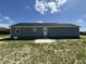 View of the back of this grey house, featuring a door, windows, and fresh landscaping at 82 Asher Pointe Way, Benson, NC 27504