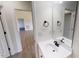 Bright bathroom featuring a white vanity, black fixtures, and a large mirror, with an open view to an adjacent room at 82 Asher Pointe Way, Benson, NC 27504