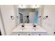 This bathroom features double sinks with black hardware, large mirror and sleek modern fixtures at 82 Asher Pointe Way, Benson, NC 27504