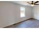 An empty, bright bedroom with a window and modern flooring and a ceiling fan at 82 Asher Pointe Way, Benson, NC 27504