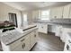 Well-lit kitchen with granite countertops, white cabinets, and a functional island at 82 Asher Pointe Way, Benson, NC 27504