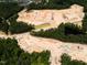 Aerial view of a construction site for a new development with earth moving equipment in a lush, green area at 8717 Wardle Ct, Raleigh, NC 27616