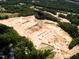 Aerial view of a large construction site with excavation work, roads, and equipment surrounded by forest at 8717 Wardle Ct, Raleigh, NC 27616
