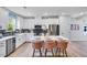 Bright kitchen features white cabinets, stainless appliances, island with seating and stylish backsplash at 8717 Wardle Ct, Raleigh, NC 27616