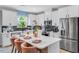 Well-lit kitchen featuring white cabinets, stainless steel appliances, and a center island with comfortable seating at 8717 Wardle Ct, Raleigh, NC 27616