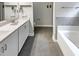 Bathroom features a double vanity, tile flooring, and a soaking tub with tile surround at 95 Cinnamon Teal Way, Youngsville, NC 27596