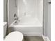 Bathroom featuring a tub and shower combo with tile surround and modern toilet at 95 Cinnamon Teal Way, Youngsville, NC 27596