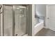 Modern bathroom featuring a glass door shower and a separate soaking tub with stylish fixtures at 95 Cinnamon Teal Way, Youngsville, NC 27596