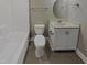 Well-lit bathroom featuring a white vanity with storage, toilet, bathtub and neutral paint at 95 Cinnamon Teal Way, Youngsville, NC 27596