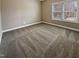 An empty bedroom with carpet flooring and a window letting in natural light at 95 Cinnamon Teal Way, Youngsville, NC 27596