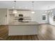 Modern kitchen with a center island, stainless steel appliances, and sleek white cabinetry at 95 Cinnamon Teal Way, Youngsville, NC 27596