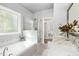 Bathroom featuring a soaking tub, glass shower, and dual vanity with marble countertops at 1002 Augustine Trl, Cary, NC 27518