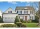 Charming two-story traditional home featuring an attached garage, landscaped yard, and a welcoming front porch at 1002 Augustine Trl, Cary, NC 27518