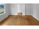 Bedroom with hardwood flooring and open closet featuring bi-fold doors at 1004 Carlisle St, Raleigh, NC 27610