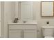 Bright bathroom with a modern vanity, a decorative mirror, and a toilet with a plant at 1006 Sora Way, Durham, NC 27703