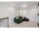 Spacious bonus room with a comfortable green sofa, stylish artwork, and neutral walls at 1010 Sora Way, Durham, NC 27703