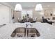 Modern kitchen featuring granite countertops, a stainless steel sink, and a dining area with stylish lighting fixtures at 1010 Sora Way, Durham, NC 27703