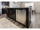 Kitchen island with black cabinets, stainless steel dishwasher, and granite countertops on wood grain floors at 1010 Sora Way, Durham, NC 27703