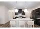 Open kitchen with an island featuring granite countertops and modern pendant lighting at 1010 Sora Way, Durham, NC 27703