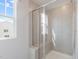 Modern walk-in shower with glass door, tile surround, and a window for natural light at 1010 Sora Way, Durham, NC 27703