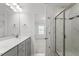 Bathroom featuring double vanity, framed mirrors, and glass door shower with marble surround at 1018 Salt Glaze Ln, Cary, NC 27519