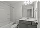 Clean bathroom with tub, white fixtures, and functional vanity, complemented by soft lighting at 1018 Salt Glaze Ln, Cary, NC 27519
