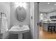 Powder room with a pedestal sink and hardwood floors leading to a kitchen with an island at 112 Huntsmoor Ln, Cary, NC 27513