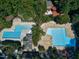 Aerial view of the community pool, complete with lounge chairs and umbrellas, surrounded by trees at 115 Ripplewater Ln, Cary, NC 27518