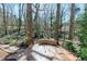 Stamped concrete patio with a sitting wall feature and surrounded by mature trees at 115 Ripplewater Ln, Cary, NC 27518