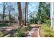 Landscaped backyard featuring mature trees, flowerbeds, and a stone patio at 115 Ripplewater Ln, Cary, NC 27518