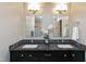Bathroom featuring a double vanity with granite countertop, decorative mirrors, and modern lighting at 115 Ripplewater Ln, Cary, NC 27518
