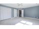 Bright bedroom featuring a ceiling fan, neutral carpet, closet and large window at 115 Ripplewater Ln, Cary, NC 27518