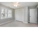Bright bedroom featuring a ceiling fan, neutral carpet, closet and large window at 115 Ripplewater Ln, Cary, NC 27518